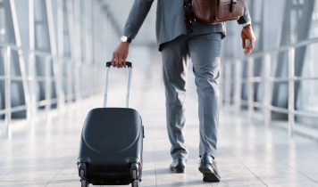 Business Trip. Businessman Carrying Suitcase, Back View