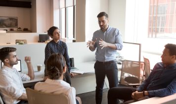 Serious Team Leader Talk To Diverse Business People At Meeting