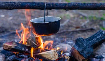 Preparing Food On Campfire In An Open Fire In A Travel Pot In Wi